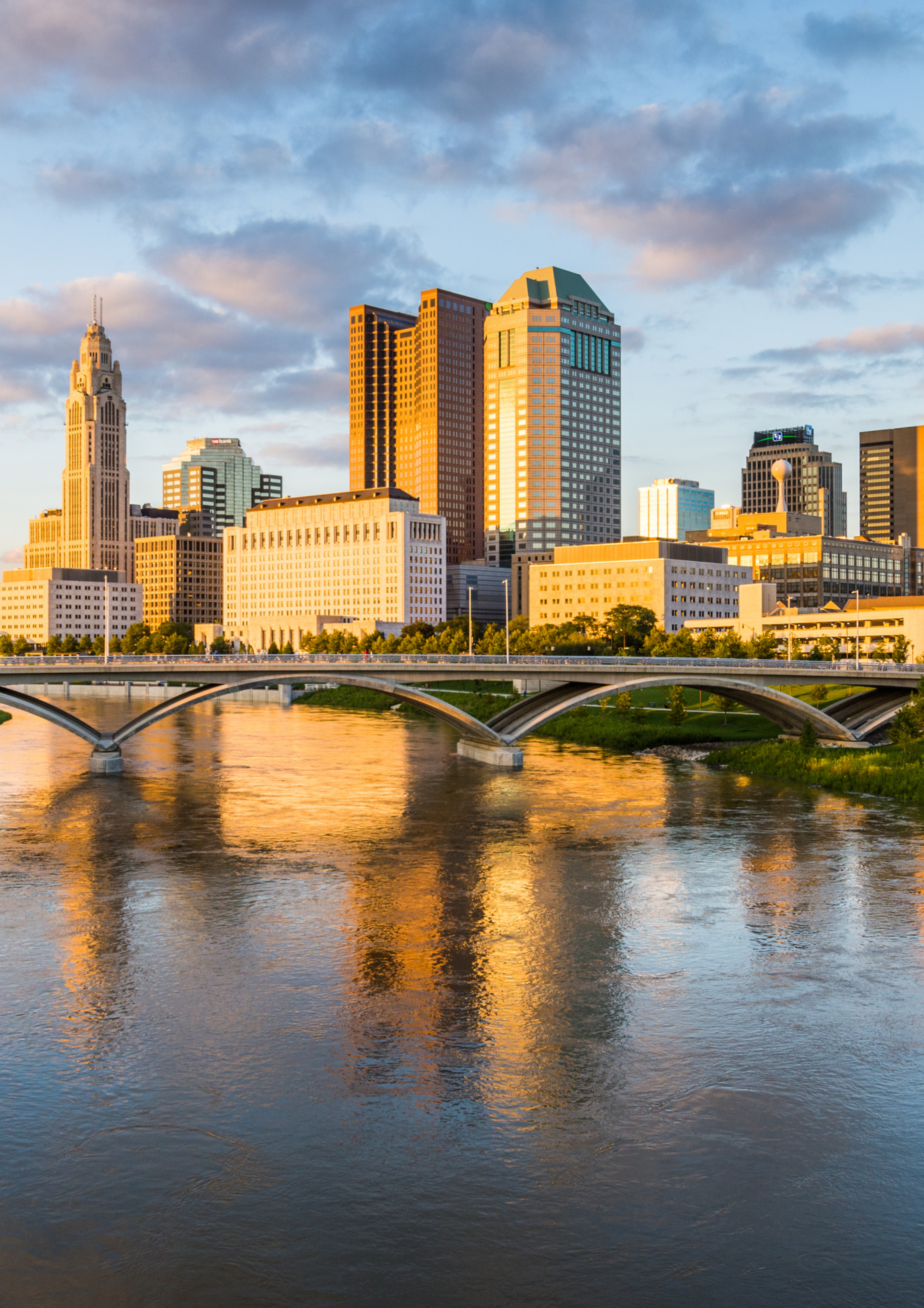 Columbus, Ohio city skyline with large city buildings and bridge over a river