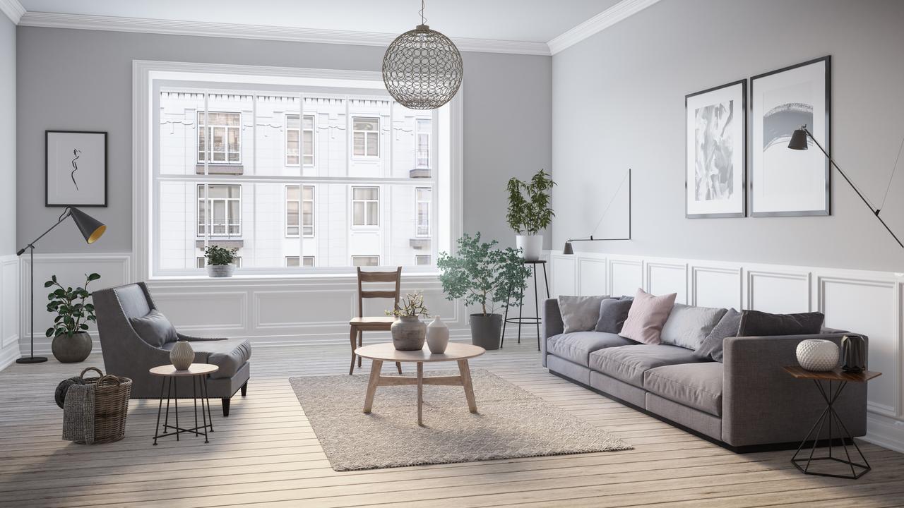 A grey colored room with grey decor including a grey couch on the right, a grey rug in the center with a wooden circle table and a grey lounge chair on the left