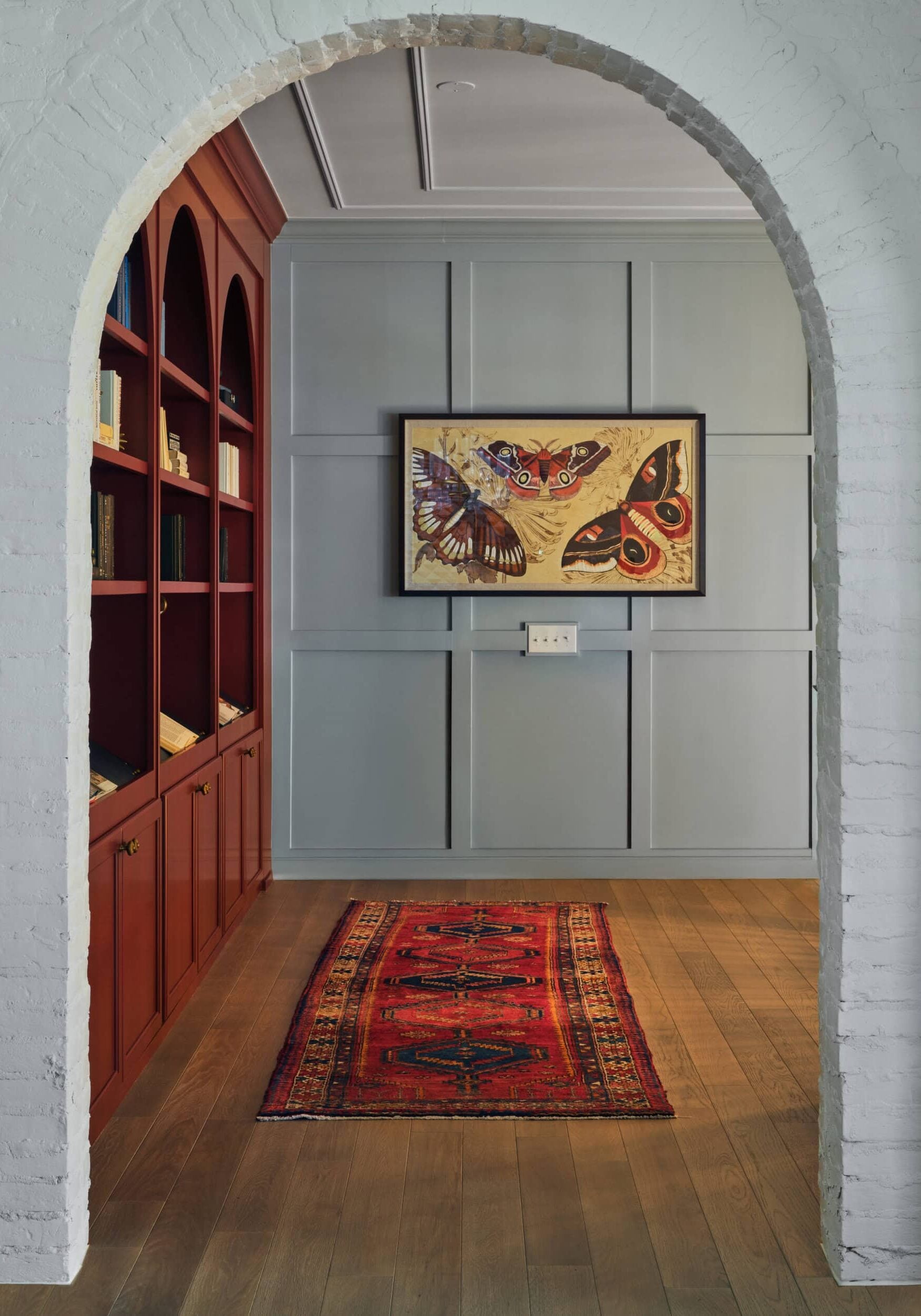 A room with a bookcase and a painting on the wall.