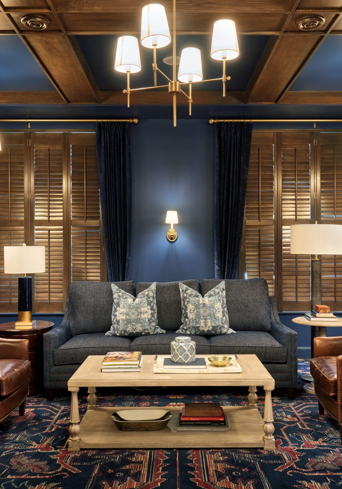 A room with a couch and chairs.